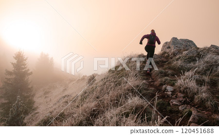 trail running woman athlete training for ultra-marathon race in a mountain 120451688