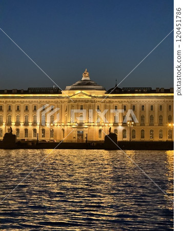 Illuminated Historic Building Reflected on River at Dusk 120451786