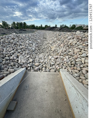 Rocky Dry Riverbed Under Cloudy Sky in Urban Area Rocky Dry Riverbed Under Cloudy Sky in Urban Area 120451797
