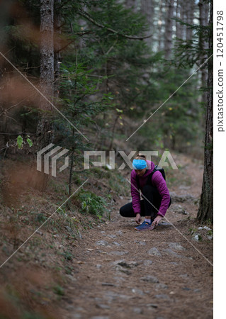 Trail runner hiking woman tying laces on trail run and hike Trail runner hiking woman tying laces on trail run and hike 120451798