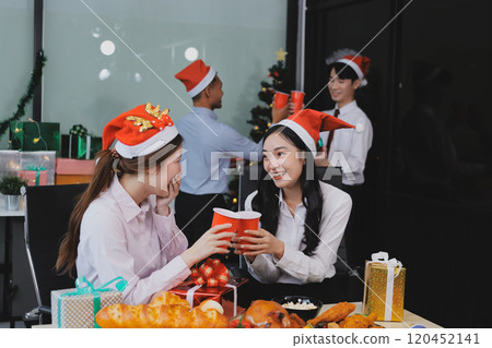 full length view of a group of business team wearing red Santa hat and exchange gift box together in the office for Christmas. full length view of a group of business team wearing red Santa hat and exchange gift box together in the office for Christmas. 120452141