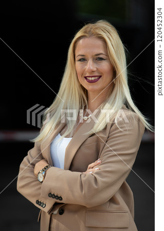 A powerful portrait of a businesswoman, standing confidently with her arms crossed A powerful portrait of a businesswoman, standing confidently with her arms crossed 120452304
