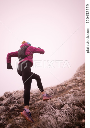 trail running woman athlete training for ultra-marathon race in a mountain 120452359