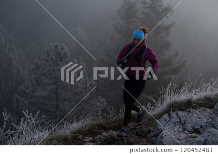 trail running woman athlete training for ultra-marathon race in a mountain 120452481