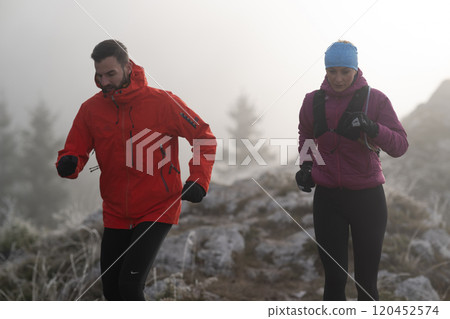 trail running couple man and woman running on a mountain path trail running couple man and woman running on a mountain path 120452574