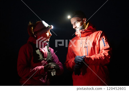 Runners tired of breathing after training look at their tech sports smart watch in night on maintain Runners tired of breathing after training look at their tech sports smart watch in night on maintain 120452601