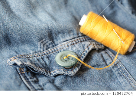 Buttons, Thread and Sewing Needle on Denim. Close-up Buttons, Thread and Sewing Needle on Denim. Close-up 120452764