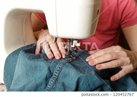 Women's hand working on sewing machine. Life at home. authentic lifestyle Women's hand working on sewing machine. Life at home. authentic lifestyle 120452767