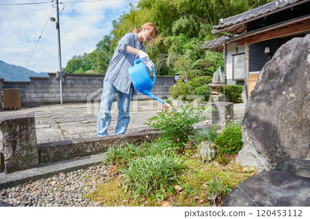 照顧花園、澆水、古老民宅、鄉村的婦女 120453112