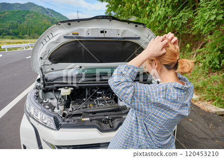 Woman holding her head in front of her car, flat tire, trouble 120453210