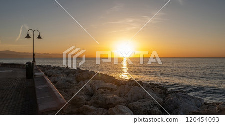 Sunset over the Mediterranean sea, seen from the coast in Torremolinos, Andalusia, Spain. 120454093