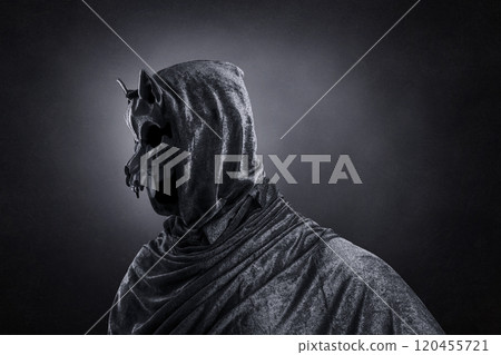 Creepy figure with animal skull at night over dark misty background 120455721