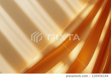 Soft orange fabric flowing with warm sunlight creating dynamic patterns on a wall 120456184