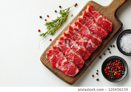 Fresh marbled beef steaks arranged on a wooden cutting board with herbs and salt Fresh marbled beef steaks arranged on a wooden cutting board with herbs and salt 120456239