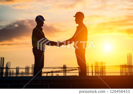 Silhouette of a construction worker working on top of a building at sunset. Silhouette of a construction worker working on top of a building at sunset. 120456433