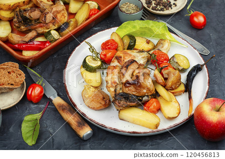 Chicken legs baked with potatoes. 120456813