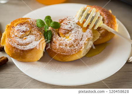 Pastries. Sweet buns with cottage cheese filling and honey in a plate on a wooden table Pastries. Sweet buns with cottage cheese filling and honey in a plate on a wooden table 120458628