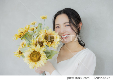 A woman holding a sunflower bouquet 120458676