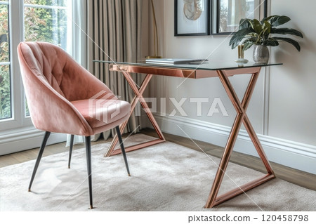 A stylish home office setup featuring a glass desk and elegant pink chair with floral decor 120458798