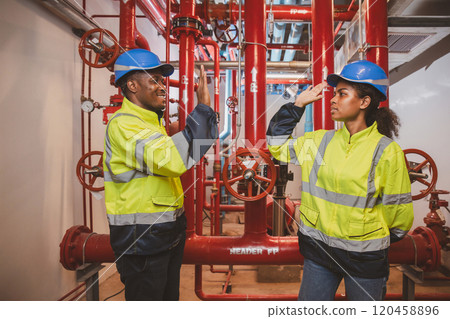 Engineer or technician work checking Fire suppression system and fire equipment. Engineer check red generator pump for water sprinkler piping and fire alarm control system 120458896