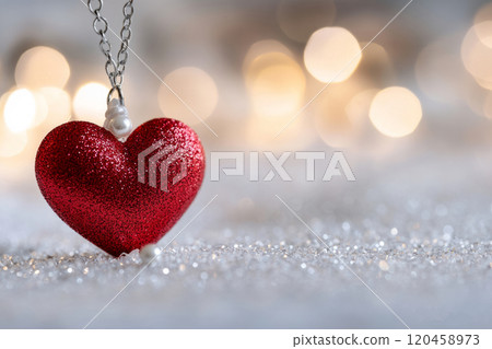 Red heart shaped pendant against a bokeh background 120458973