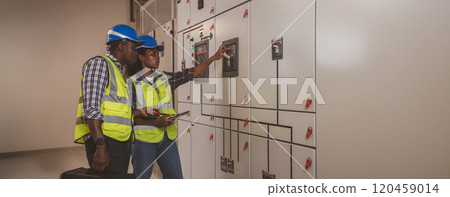 Electrical engineer team are working in control room. Electrical engineer man checking Power Distribution Cabinet in the control room Electrical engineer team are working in control room. Electrical engineer man checking Power Distribution Cabinet in the control room 120459014