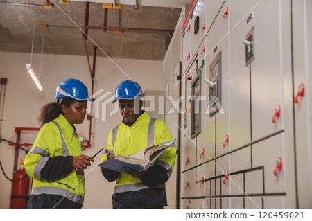 Electrical engineer team are working in control room. Electrical engineer man checking Power Distribution Cabinet in the control room Electrical engineer team are working in control room. Electrical engineer man checking Power Distribution Cabinet in the control room 120459021