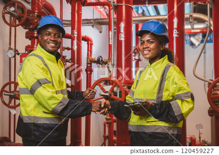 Electrical engineer team are working in control room. Electrical engineer man checking Power Distribution Cabinet in the control room Electrical engineer team are working in control room. Electrical engineer man checking Power Distribution Cabinet in the control room 120459227