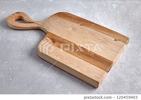 figured wooden board for cutting vegetables on a gray stone table figured wooden board for cutting vegetables on a gray stone table 120459403