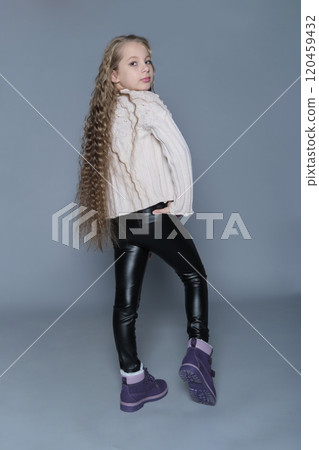 A girl strikes a confident pose in her sweater and dark leggings, exuding natural charm. This portrait highlights the blend of casual style and quiet confidence found in young individuals. A girl strikes a confident pose in her sweater and dark leggings, exuding natural charm. This portrait highlights the blend of casual style and quiet confidence found in young individuals. 120459432