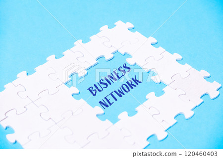 A white puzzle piece with the word business network written in blue 120460403