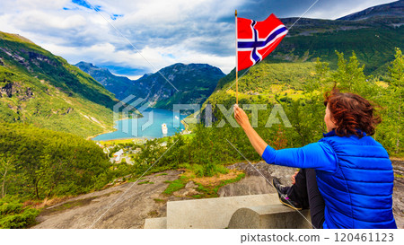 Tourist over Geirangerfjord holds norwegian flag 120461123