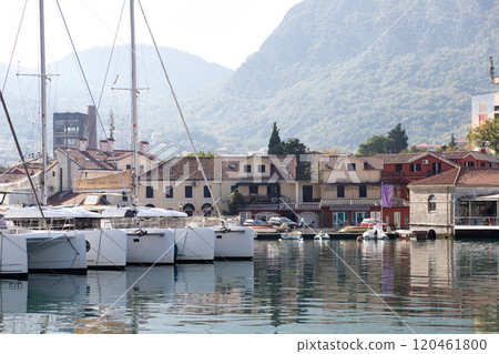 Yachts moored at the coastline in Kotor, Montenegro, with residential buildings and mountains in the background. Yachts moored at the coastline in Kotor, Montenegro, with residential buildings and mountains in the background. 120461800