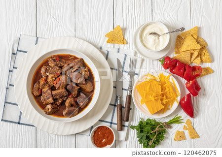beef stew in a white bowl on rustic wooden table 120462075
