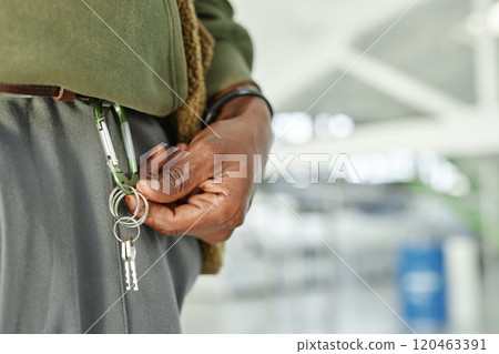 Close up on hand of Black man holding keys of rented self storage unit hanging from carabiner at warehouse, copy space 120463391