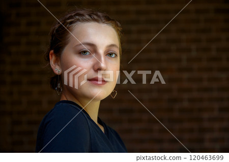 Elegant Young Woman in Black Dress with Makeup and Earrings Elegant Young Woman in Black Dress with Makeup and Earrings 120463699