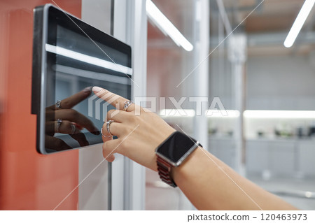 Close up on hand of woman wearing set of elegant silver rings unlocking office door using touch screen on wall, modern security system concept, copy space Close up on hand of woman wearing set of elegant silver rings unlocking office door using touch screen on wall, modern security system concept, copy space 120463973