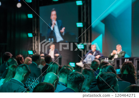 Business conference panel discussion with diverse audience engagement 120464271