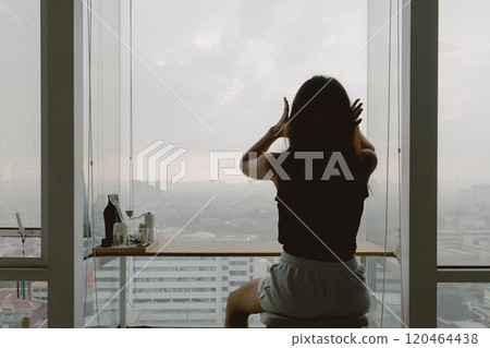 Woman relaxed at her windows apartment, enjoy the view and time. 120464438