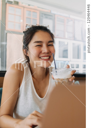 Happy woman enjoy working online remotely from a co-working space cafe. 120464446