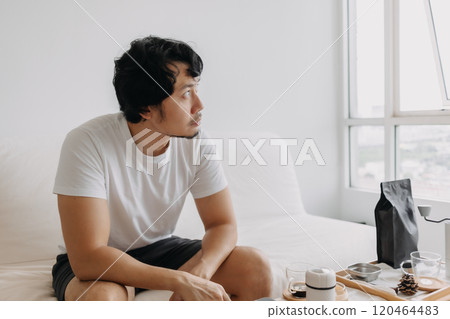 Vacant absent minded man staring out the windows, holding a coffee cup. Vacant absent minded man staring out the windows, holding a coffee cup. 120464483