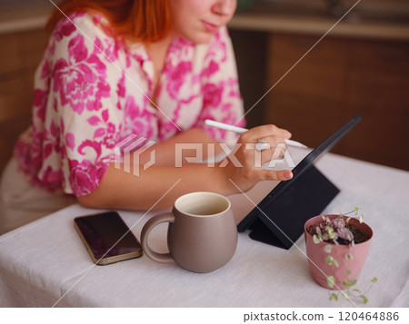 young woman working on tablet at kitchen 120464886