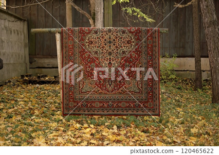 colored carpet from living room is being cleaned. dirty plaid is hanging on street. colored carpet from living room is being cleaned. dirty plaid is hanging on street. 120465622