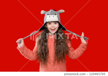 Teenager girl in a winter warm hat isolated on red. Happy girl in winter hat. Winter fashion style. Teenager knitted fashion. Outdoor lifestyle fashion. Personal style 120465785