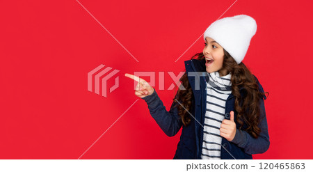 express positive emotion. winter fashion. point finger on copy space. emotional kid 120465863