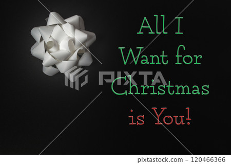 White bow with the words all I want for Christmas is you written 120466366