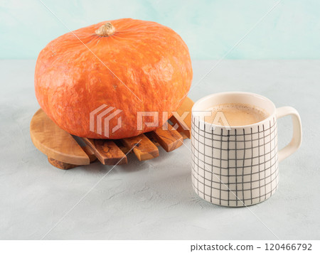 Pumpkin spiced latte coffee on turquoise background with orange squash 120466792
