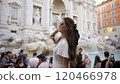 Trendy Tourist in white dress Smiling at Trevi Fountain in Rome, Italy  120466978