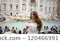 Woman in Summer Attire Posing at Trevi Fountain, Iconic Roman Destination.  120466991