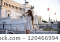 Trendy Tourist in Polka Dot Dress Standing Near Iconic Historic Monument 120466994